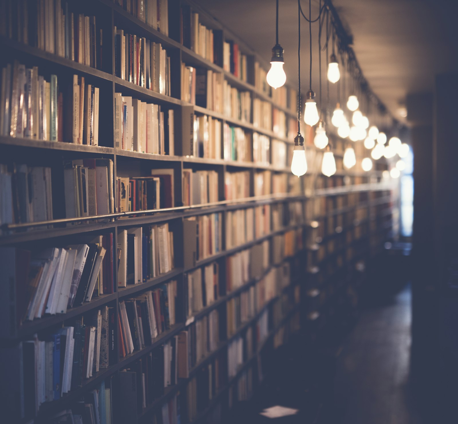 Stacked books on a library shelf representing MRI Publication's book publishing service